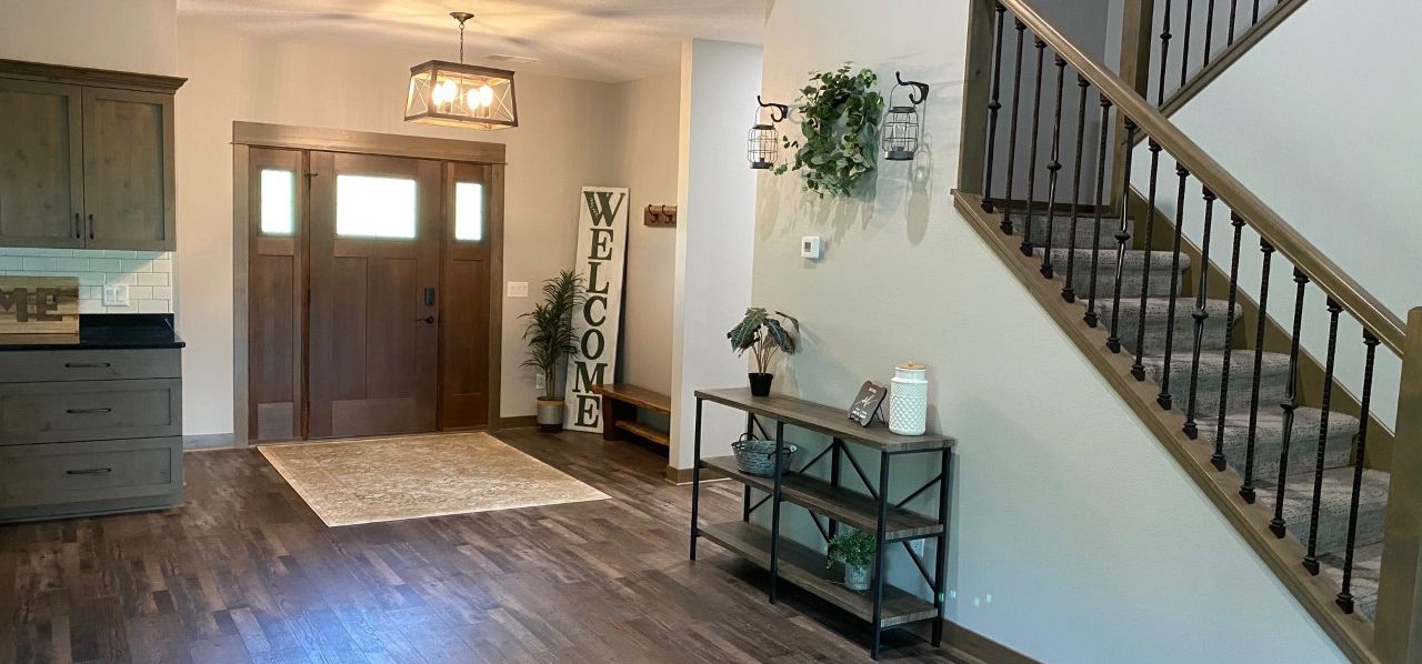 Entryway with double front doors, staircase, wood floor, and small console table