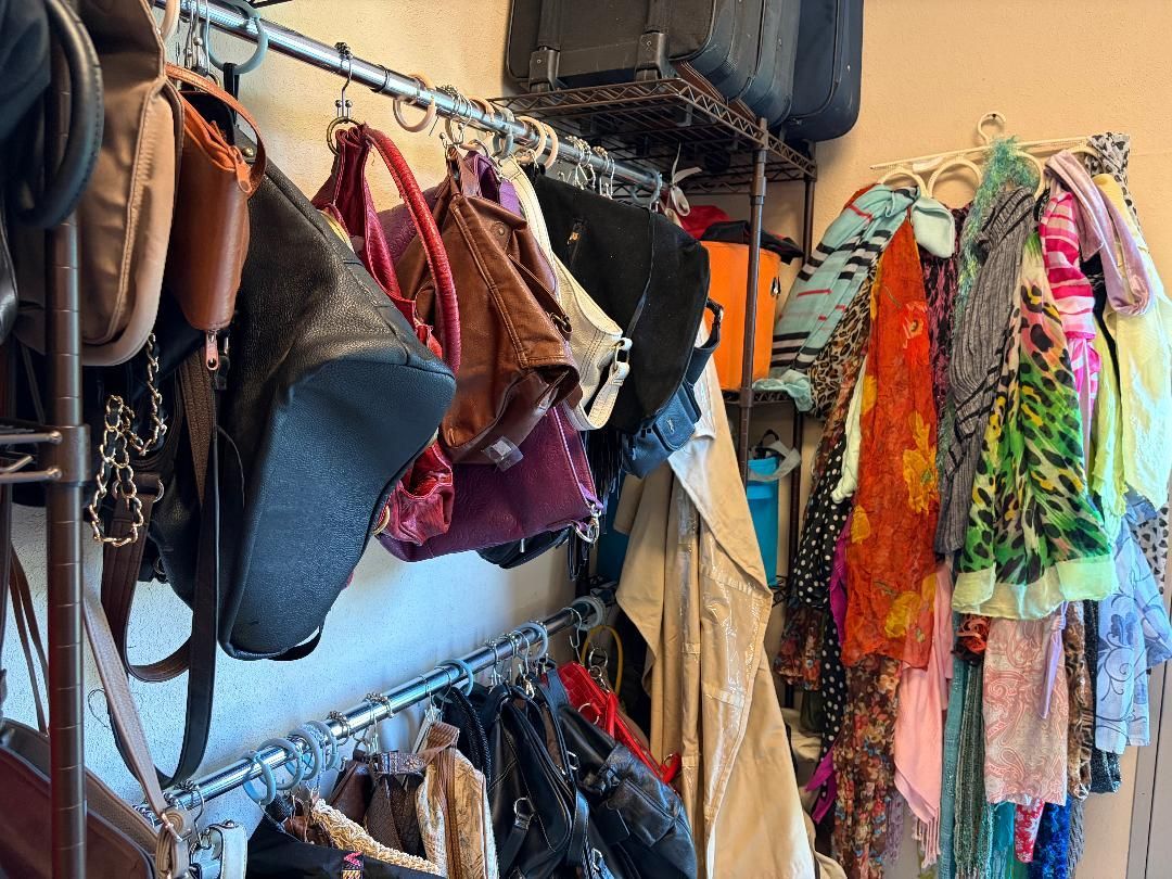 Colorful clothing and accessories hanging on racks in a crowded boutique or costume shop.