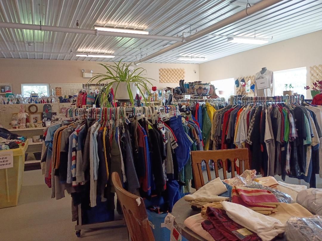Clothing store interior with racks of colorful clothes and folded garments on tables