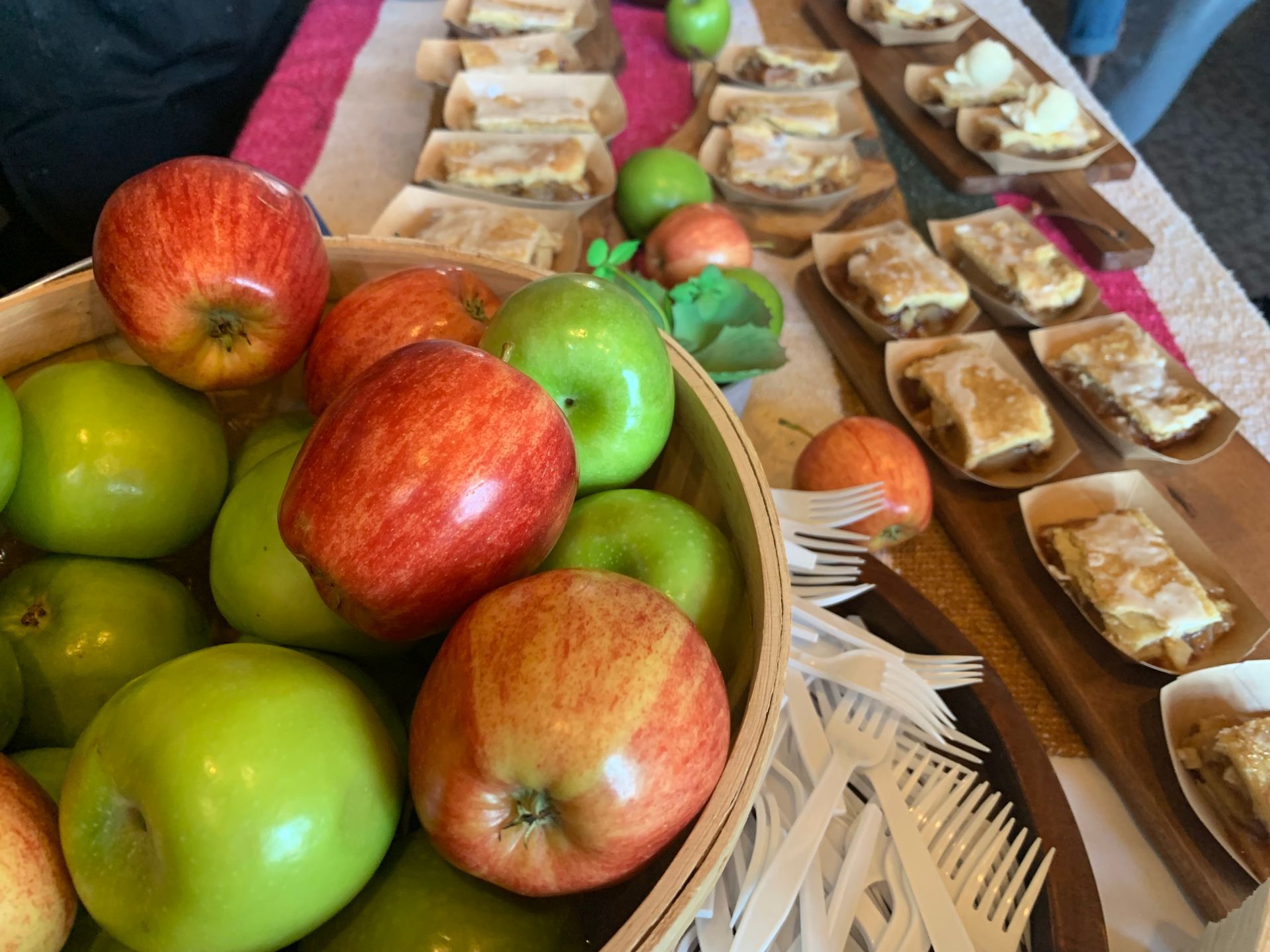 Fruit platter with apples and sandwiches arranged on a table at a buffet.