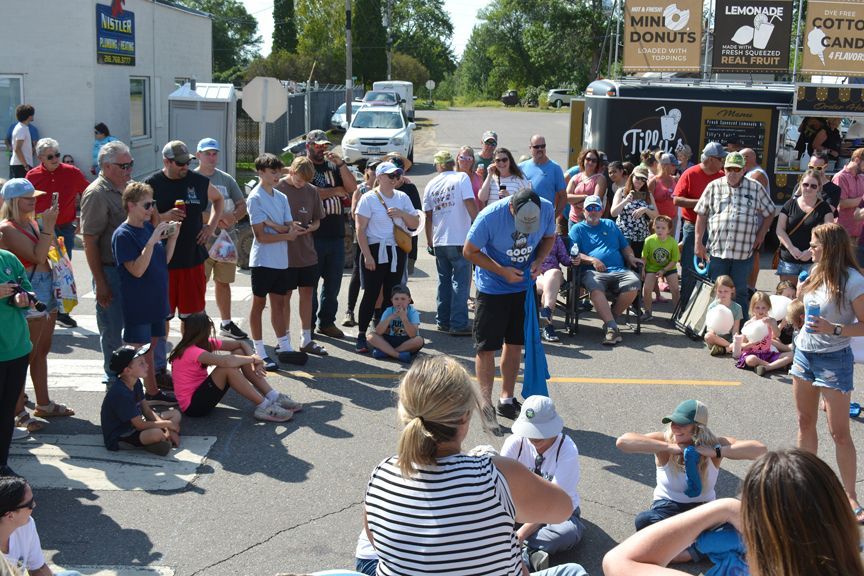 Crowd watching a street performance outdoors on a sunny day