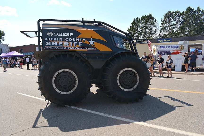 Large black off-road truck with oversized tires at an outdoor event, with “Sheep Country” branding on the side
