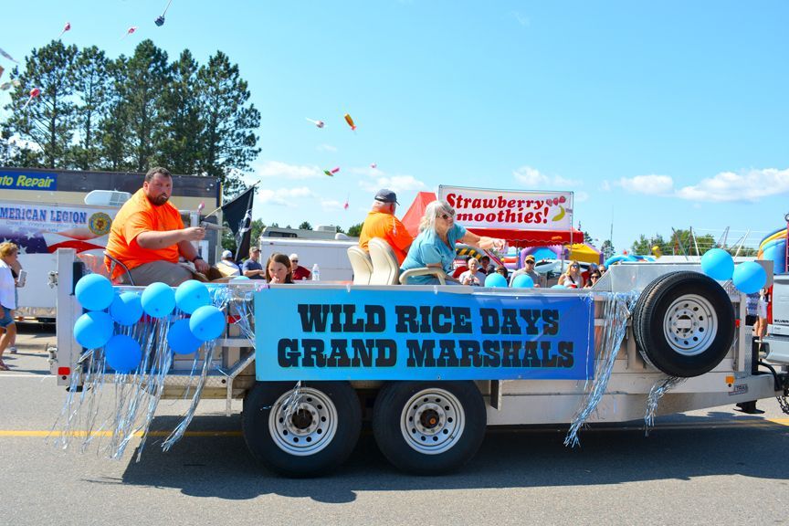 Decorated parade float with blue balloons and sign reading “Wild Rice Days Grand Marshals”
