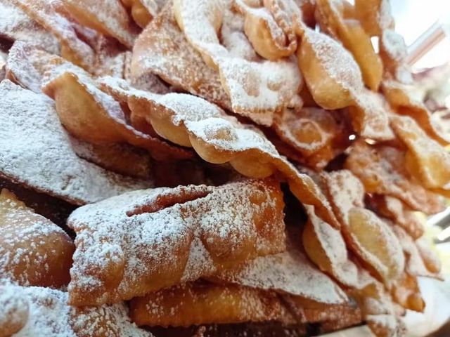 Una pila di cibo fritto con zucchero a velo sopra