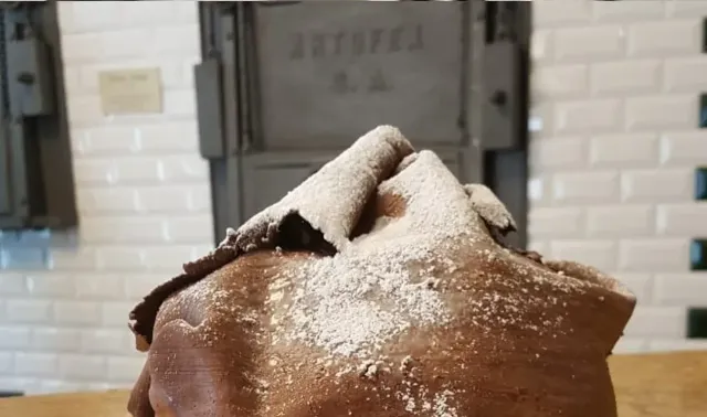 Una fetta di torta al cioccolato ricoperta di zucchero a velo su un tavolo.