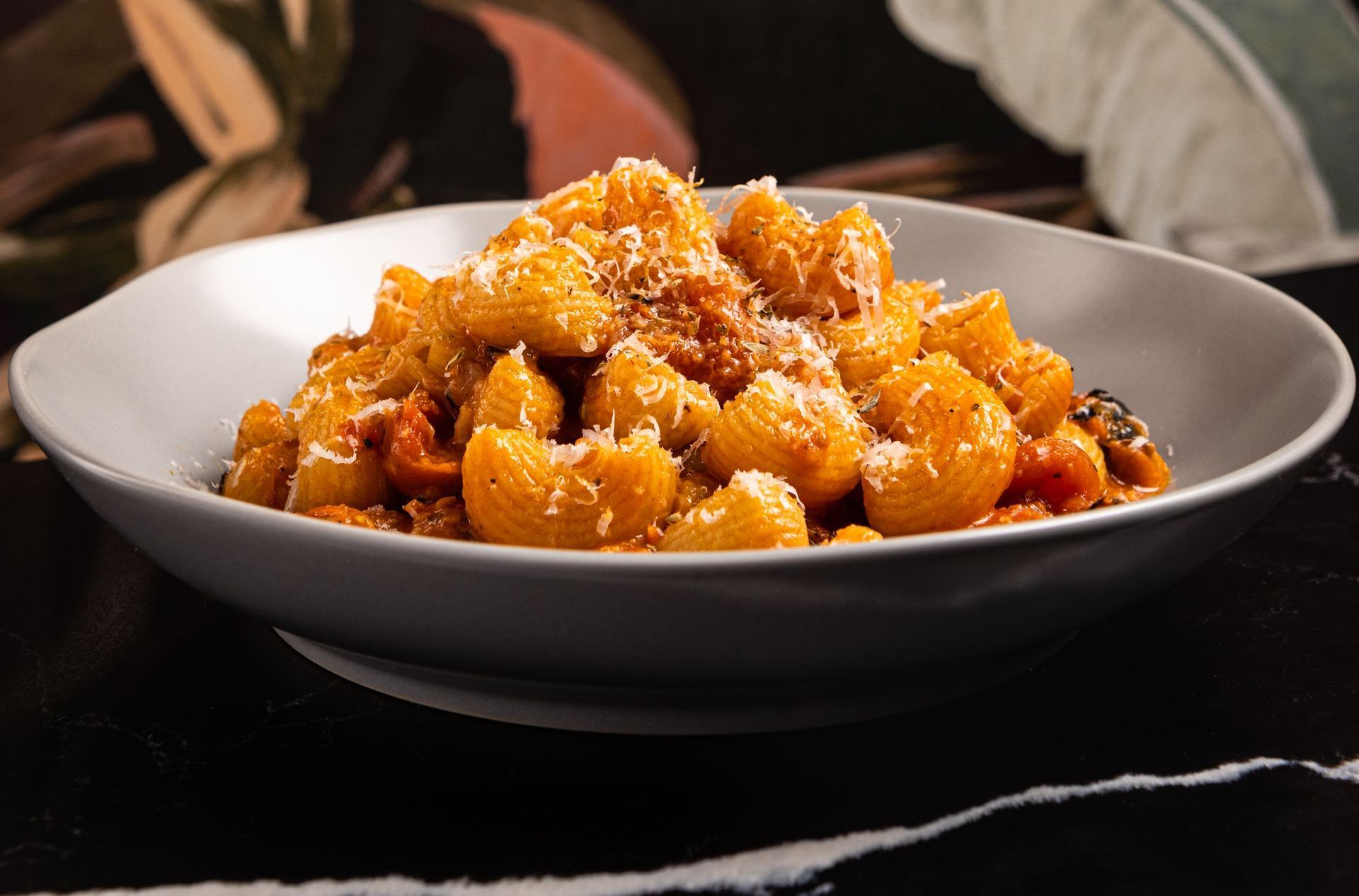 A close up of a plate of spicy rigatoni on a table.