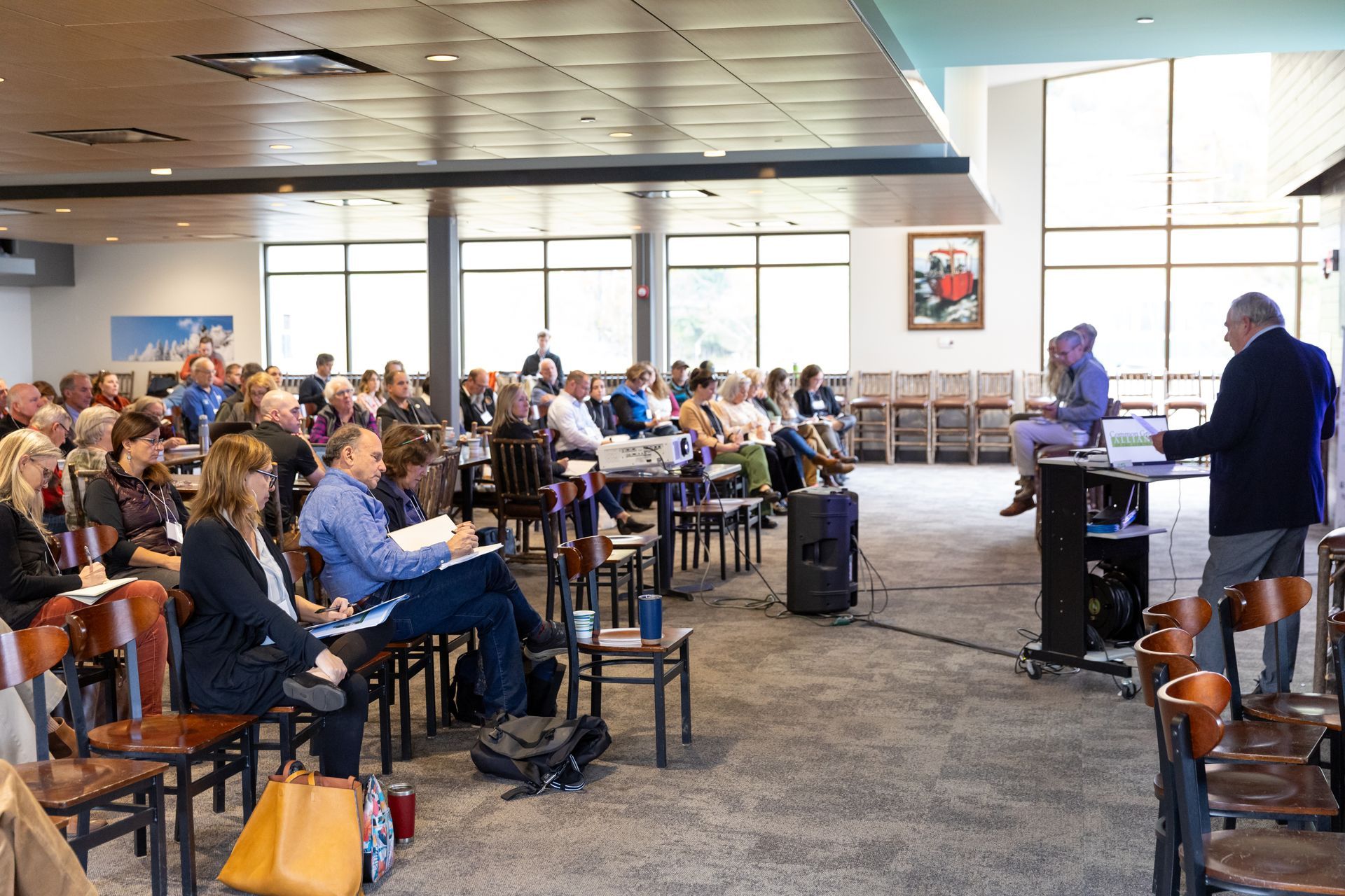 a man is giving a presentation to a large group of people