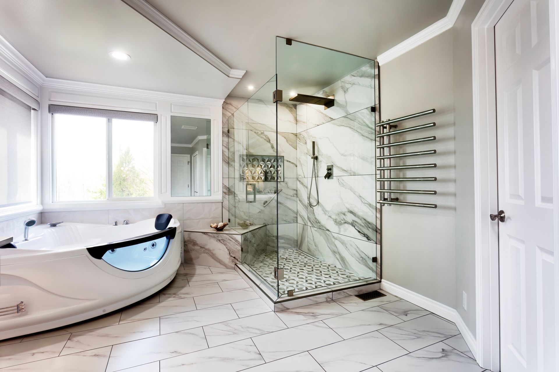 Modern bathroom with freestanding tub, glass shower, and white marble tile floor Modern bathroom with freestanding tub, glass shower, and white marble tile floor