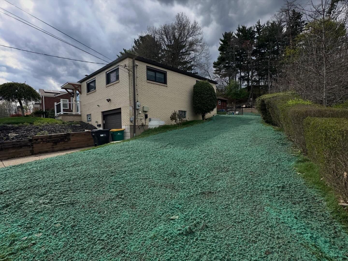 House with green gravel driveway on a cloudy day