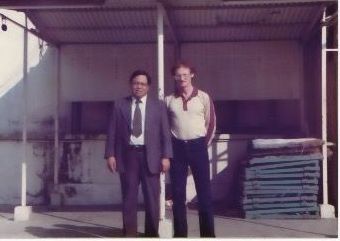 Two men standing next to each other in front of a building
