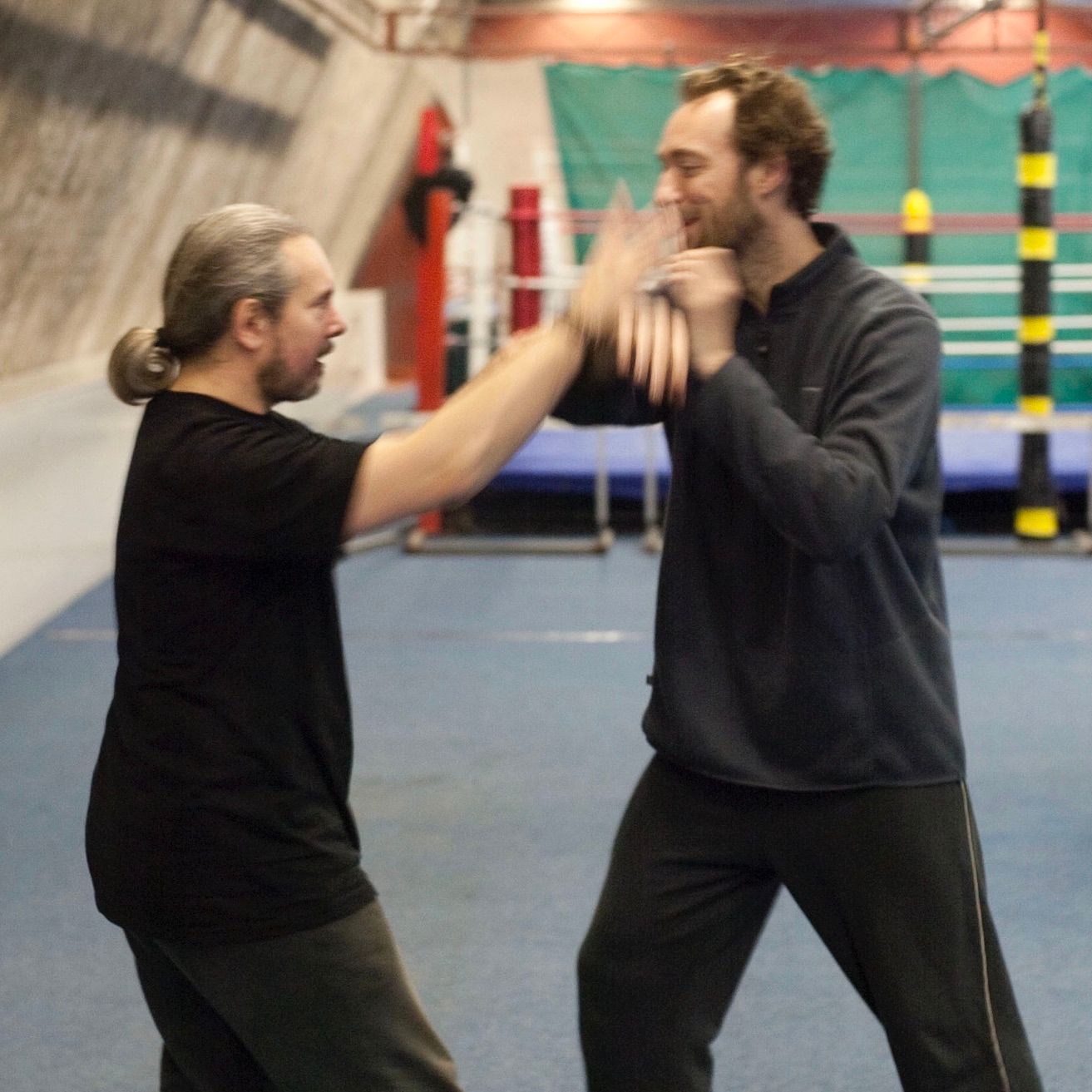 Two men are fighting in a gym and one is wearing a black shirt Tai Chi Chuan Edinburgh