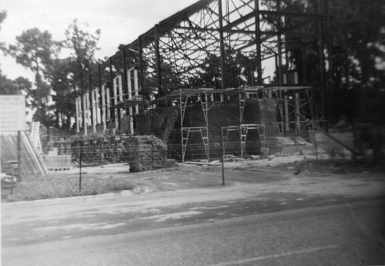 Construction site with exposed steel framework of a building and surrounding materials.
