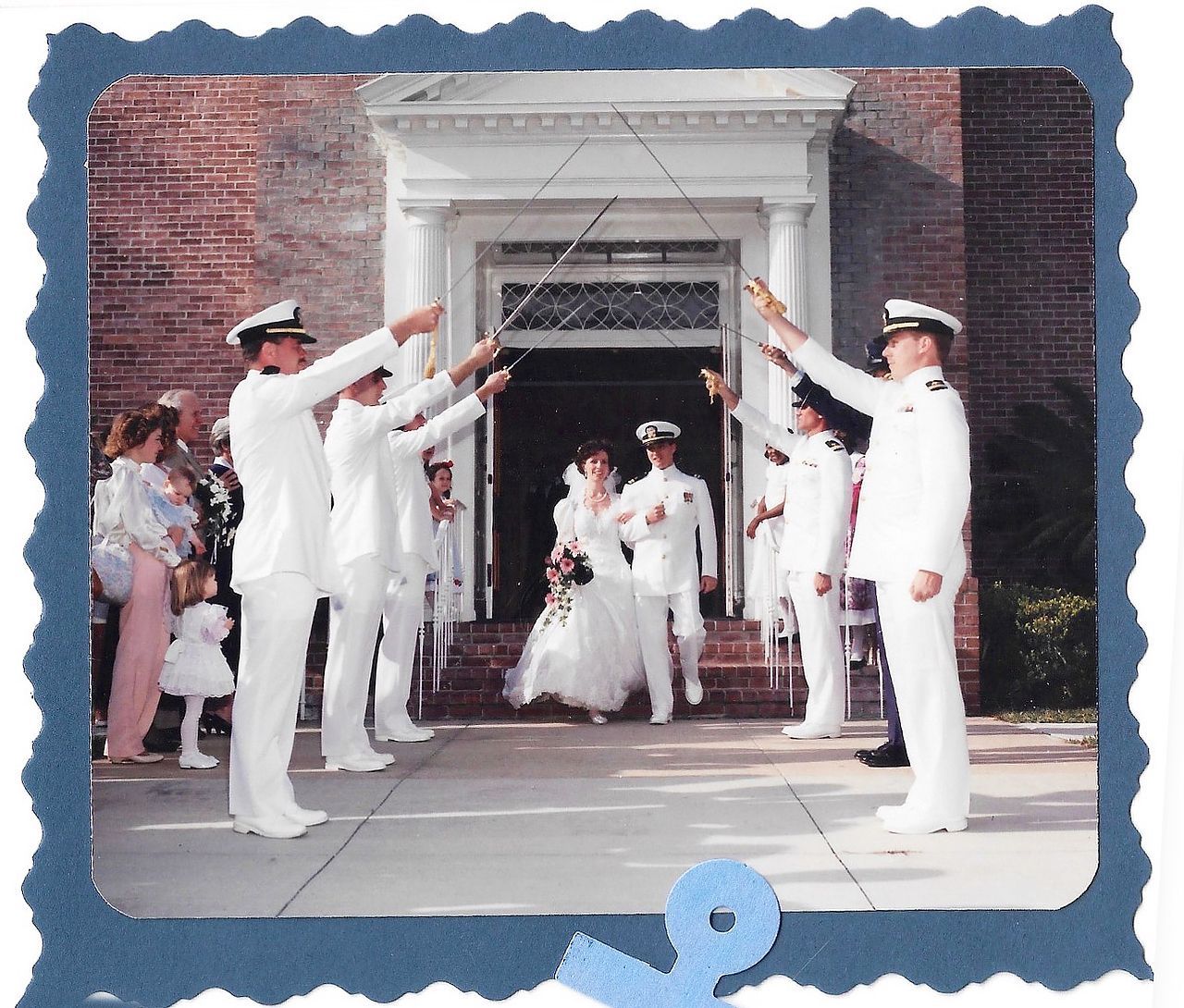 Wedding ceremony with couple exiting a church under an arch of swords held by uniformed naval officers.