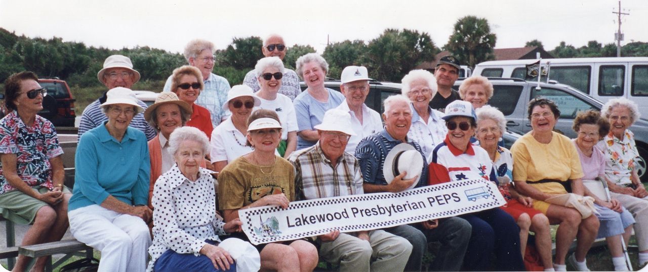 A group of people, seated and standing, holding a banner that says 