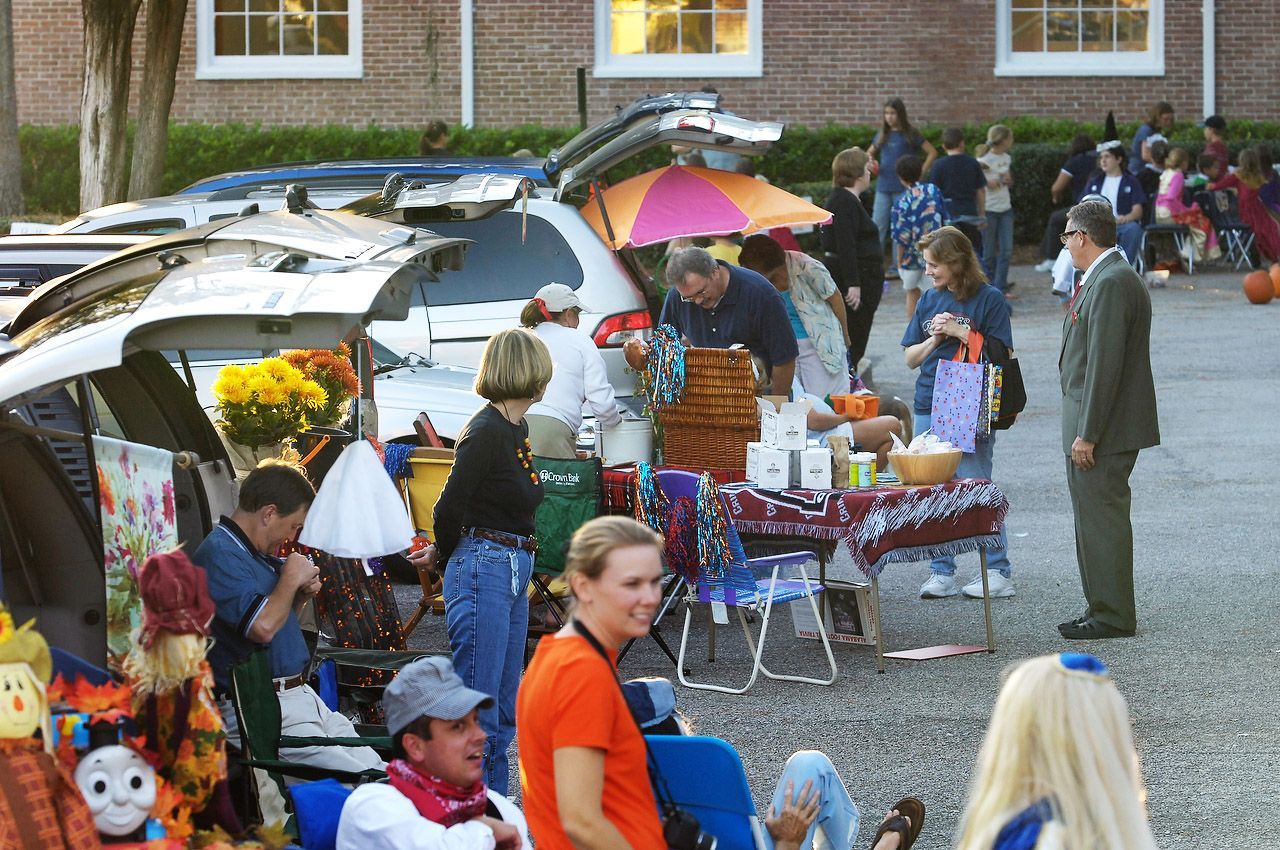 People at a fall festival, gathered around vehicles with tables
