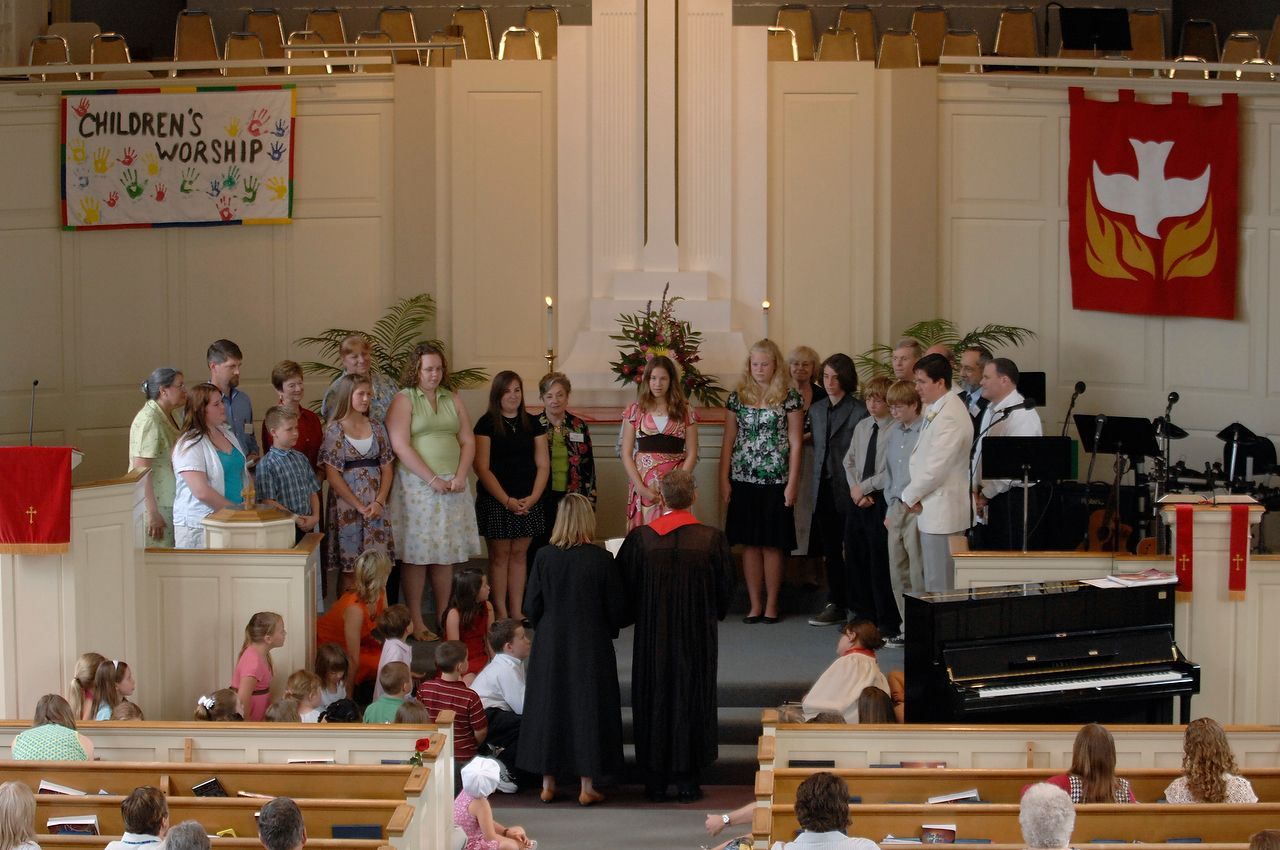 Church service: people on stage, children watching, sign 