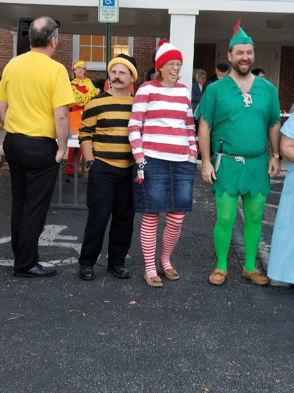 People in costumes: Yellow shirt, bumblebee, Waldo, and Peter Pan. Outdoors, daytime.