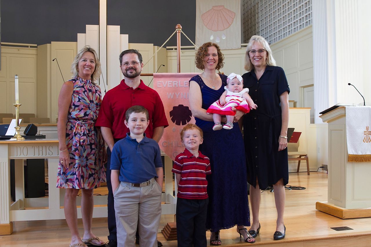 Family with a baby, two boys, and a woman at a church altar.