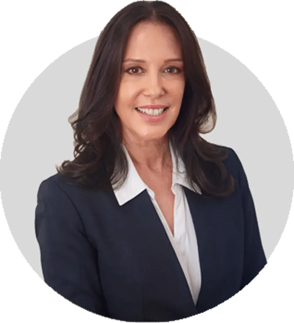 Professional woman in navy blazer and white blouse, smiling against a light gray background