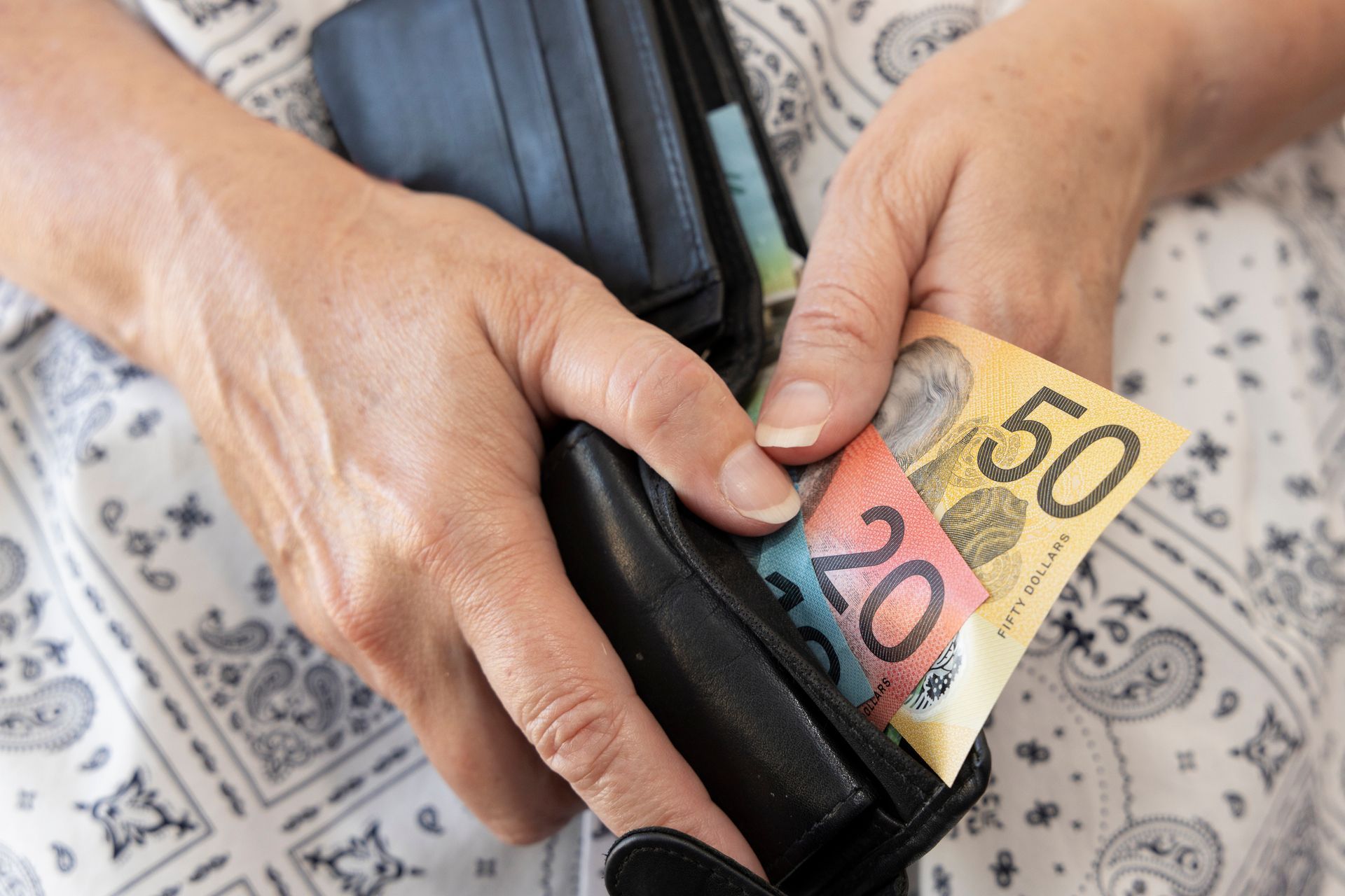 A woman is taking money out of her wallet.
