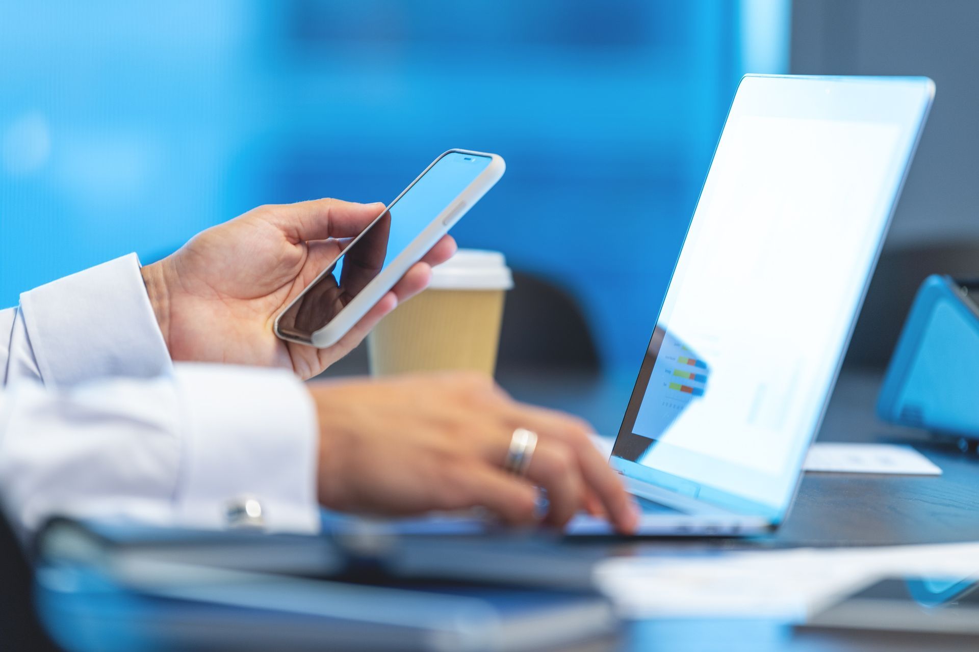 A person is using a laptop and a cell phone at the same time.