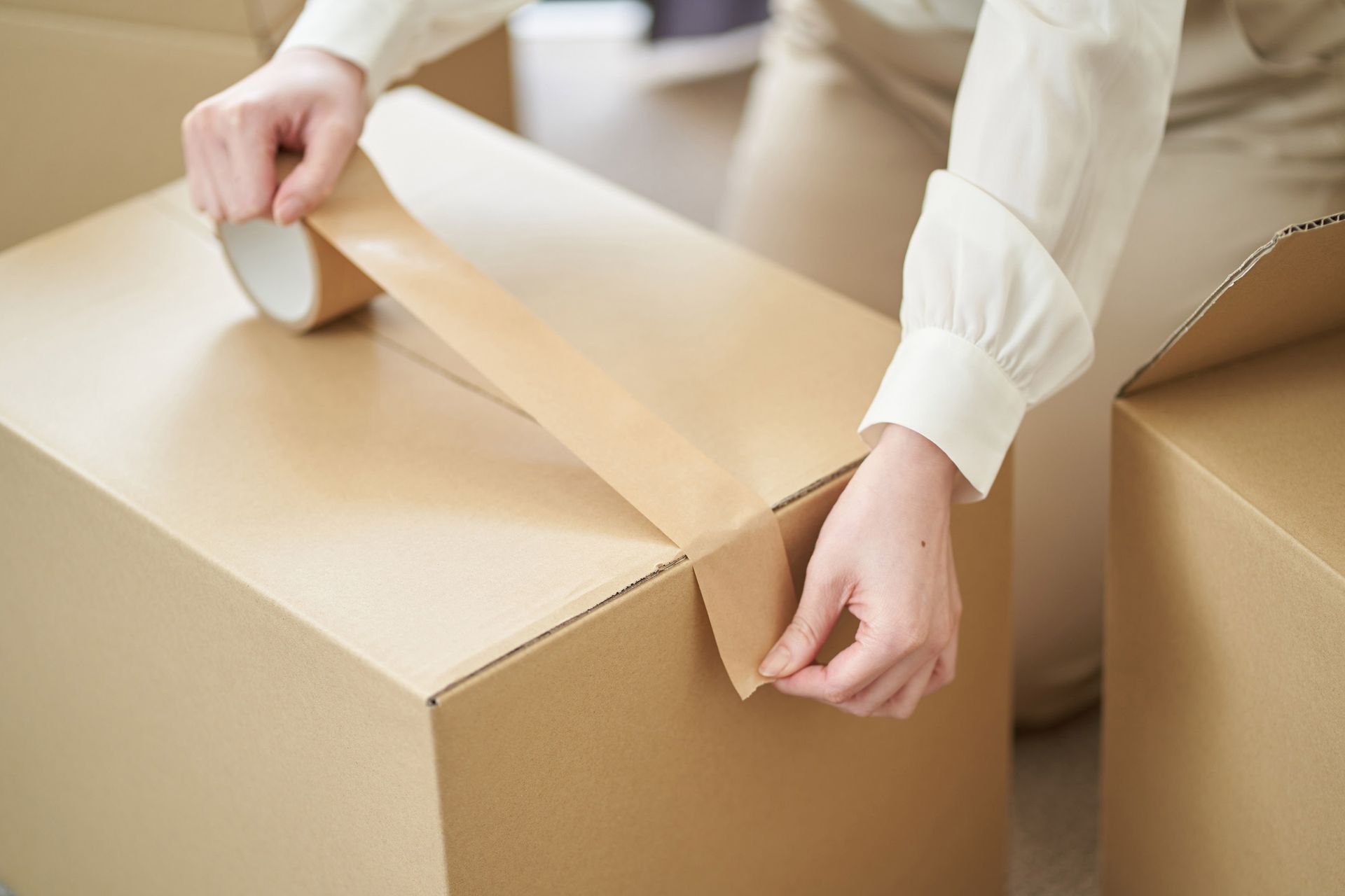 Woman Sticking Gum Tape On Cardboard — TX — Longhorn Fairy Godmother Services