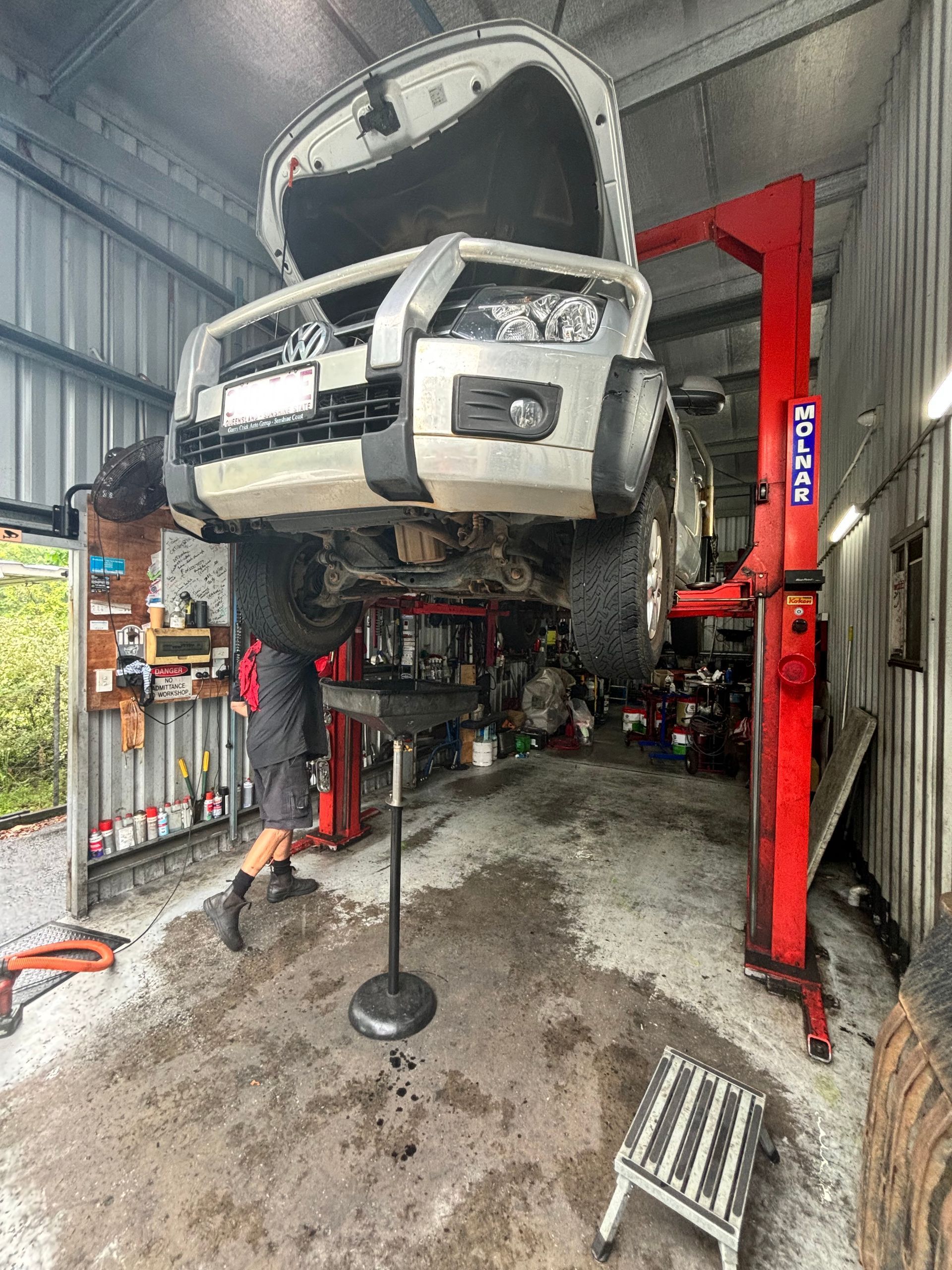A Man Is Working On A Car In A Garage — Coastwide Automotive Repairs In Nambour, QLD