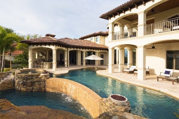 A large house with a large swimming pool in front of it