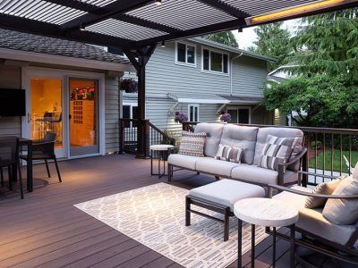 A patio with a couch and chairs under a pergola.