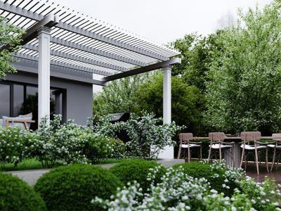A patio with a pergola and a table and chairs in the backyard of a house.
