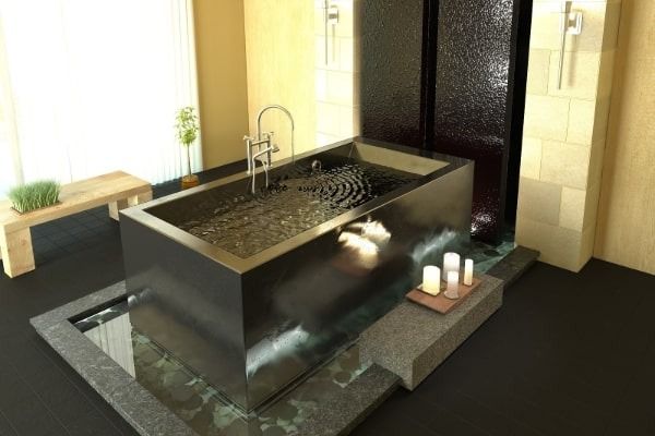 A bathroom with a bathtub and candles on the floor