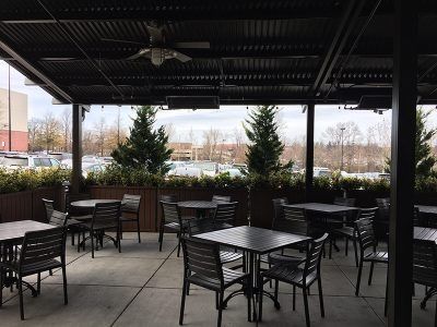 A patio with tables and chairs under a canopy.