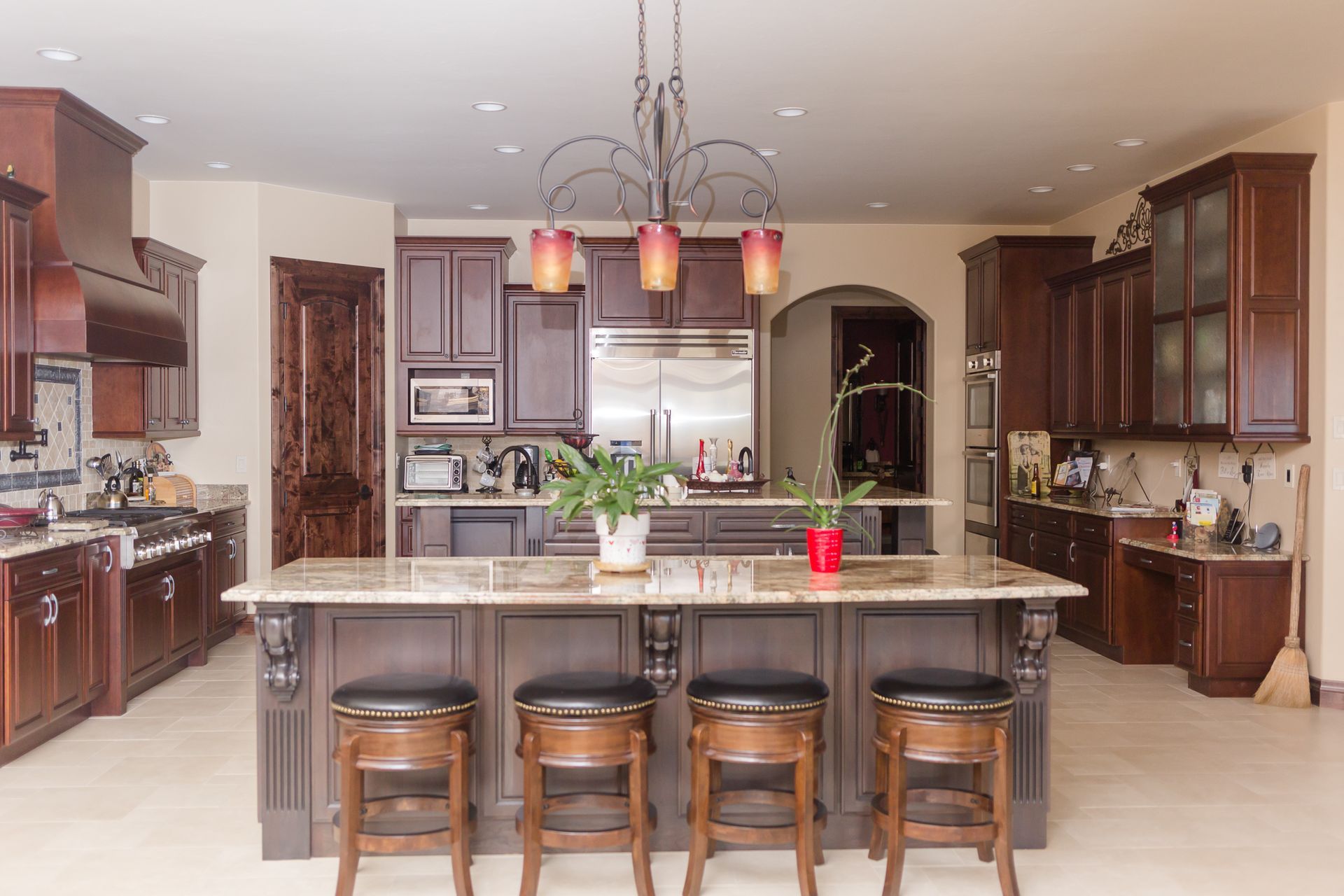 Spacious kitchen with dark wood cabinets, center island with stools, and stainless steel appliances.
