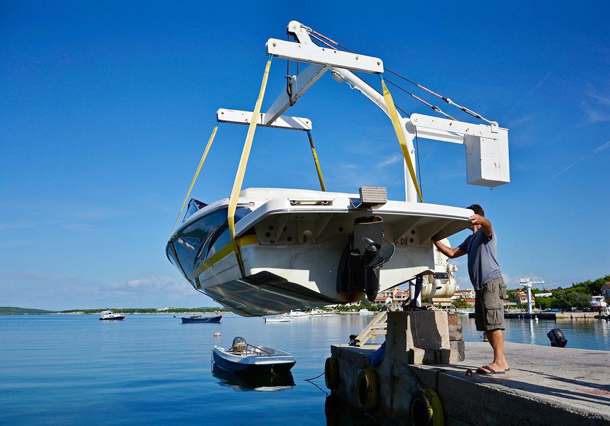 A Boat Is Being Lifted Into the Water by A Crane — Ashby Boat Builders In Buddina, QLD