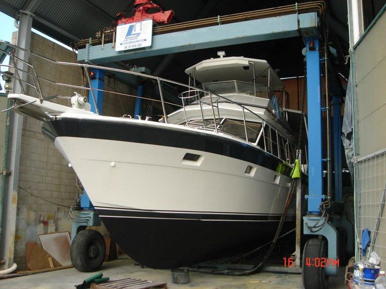 A Large Boat Is Sitting on A Lift in A Warehouse — Ashby Boat Builders In Buddina, QLD