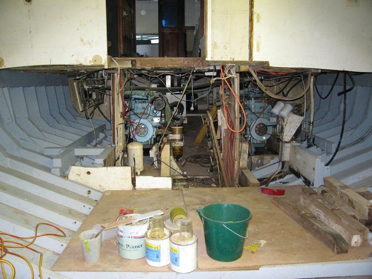 A Green Bucket Sits on A Table in Front of A Boat Under Construction — Ashby Boat Builders In Buddina, QLD