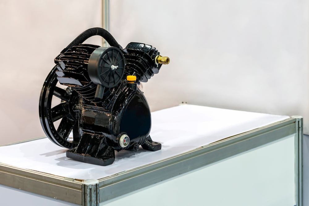 A Black Air Compressor Is Sitting on Top of A White Table — Ashby Boat Builders In Buddina, QLD