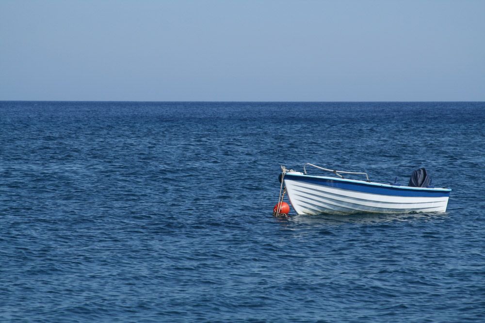 A Small Boat Is Floating on Top of A Large Body of Water — Ashby Boat Builders In Buddina, QLD