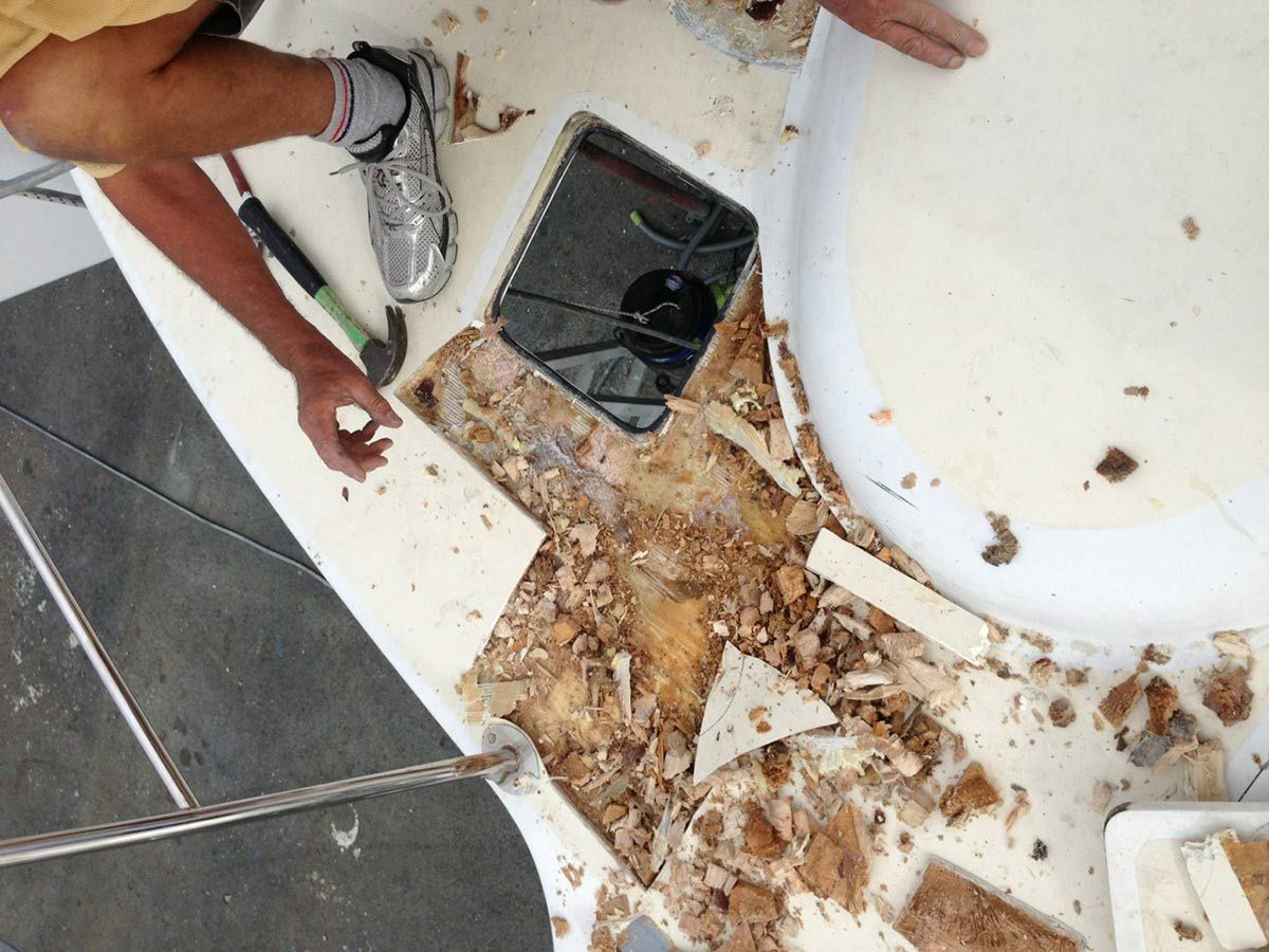 A Person Is Working on A Boat with A Hammer — Ashby Boat Builders In Buddina, QLD