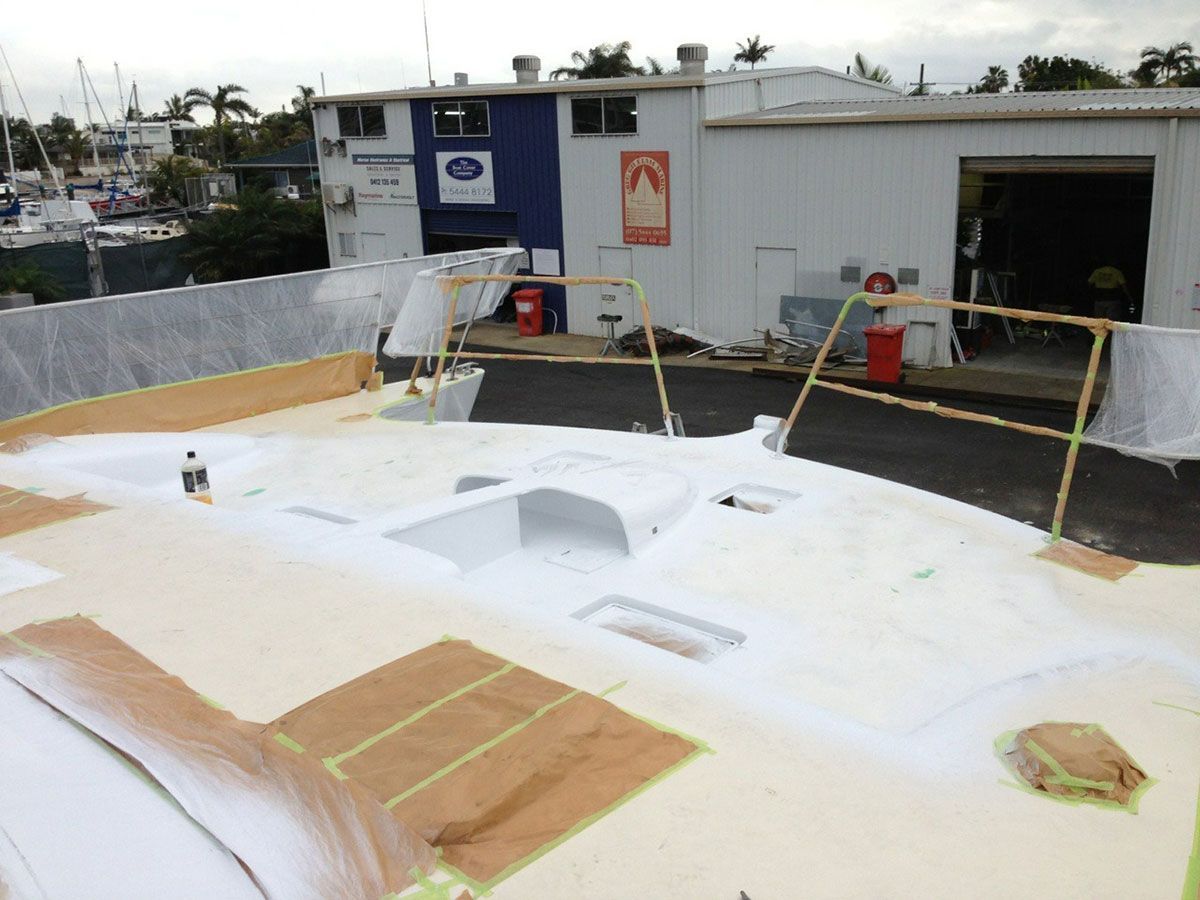 A Boat Is Being Painted in Front of A Building — Ashby Boat Builders In Buddina, QLD