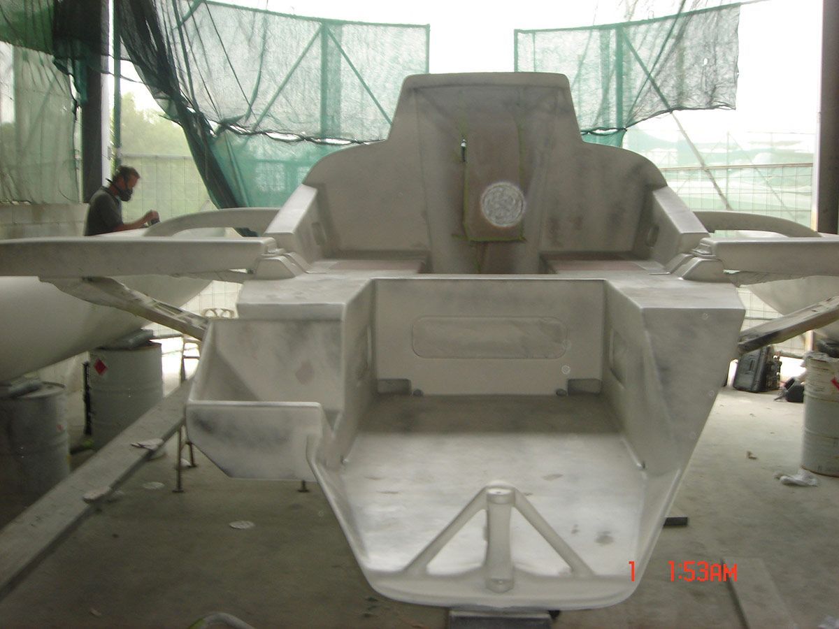 A Man Is Working on A Boat in A Warehouse — Ashby Boat Builders In Buddina, QLD
