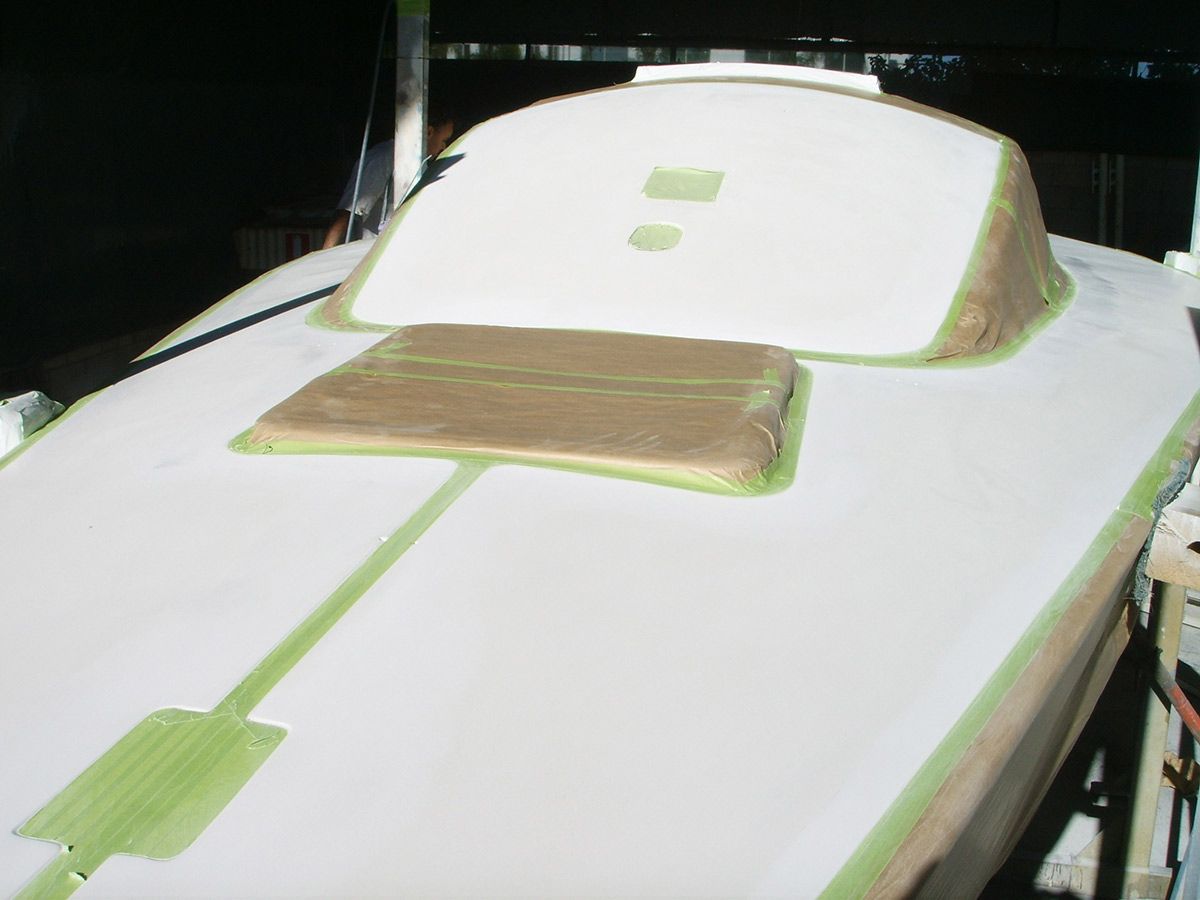 A Boat Is Being Painted with White and Green Tape — Ashby Boat Builders In Buddina, QLD