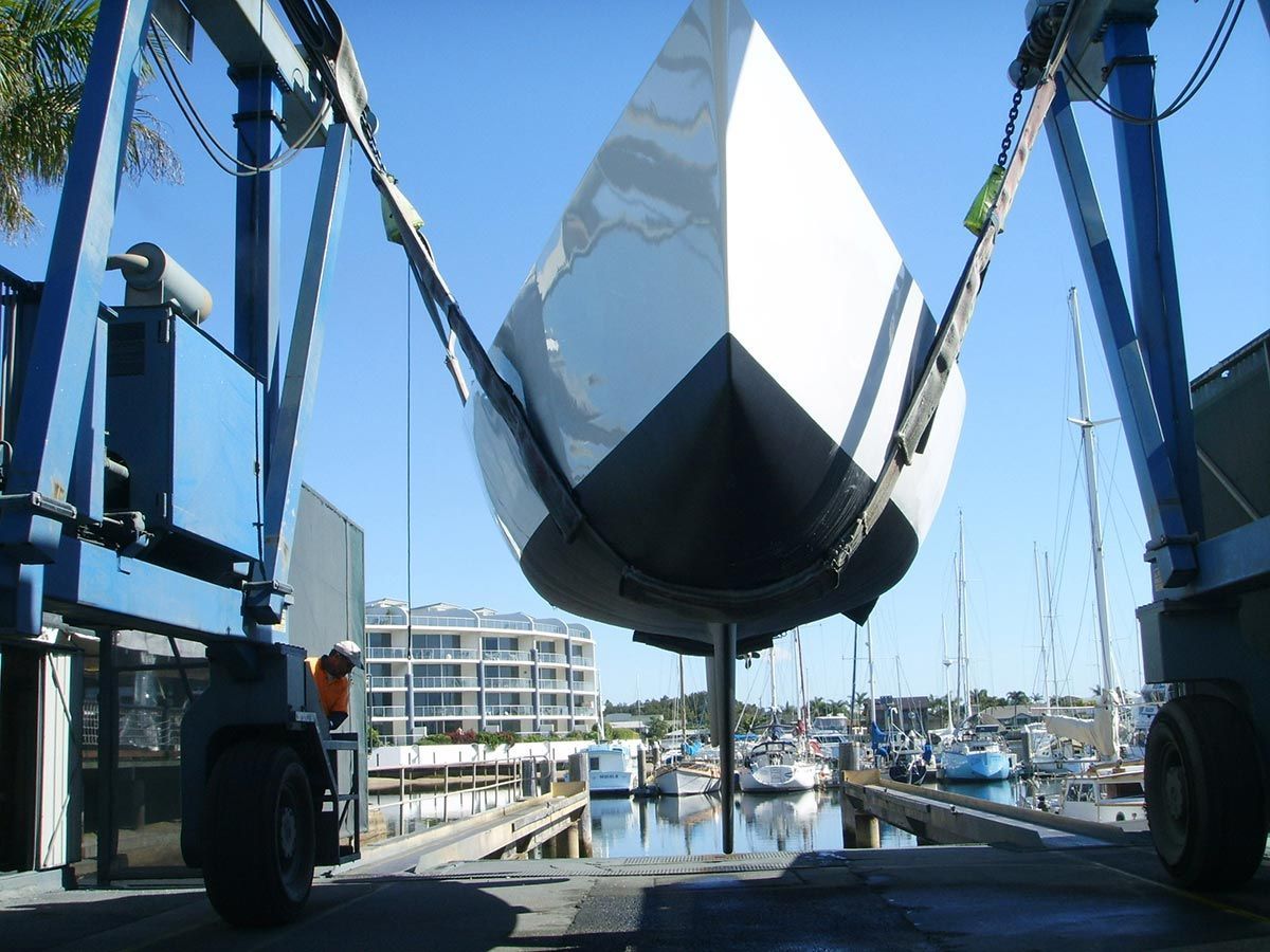 A Boat Is Being Lifted Into the Water by A Crane — Ashby Boat Builders In Buddina, QLD