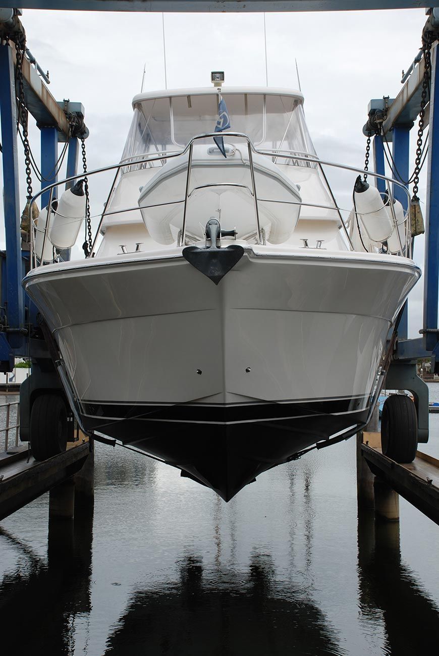 A White Boat Is Being Lifted Into the Water — Ashby Boat Builders In Buddina, QLD