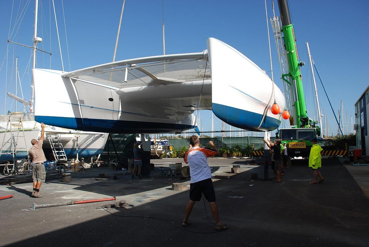 A Boat Is Being Lifted by A Crane in A Marina — Ashby Boat Builders In Buddina, QLD