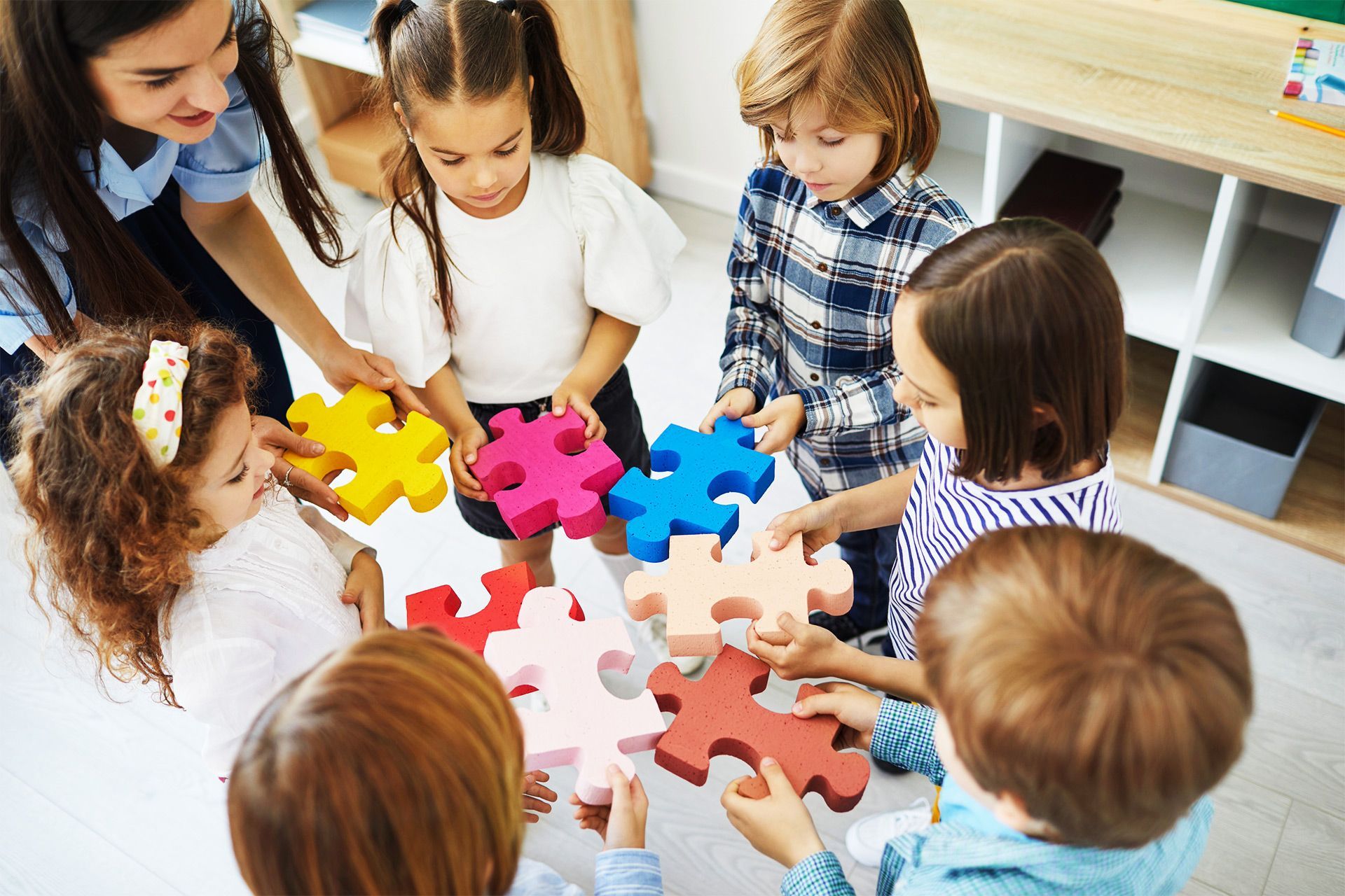 A group of children are playing with puzzle pieces in a circle.