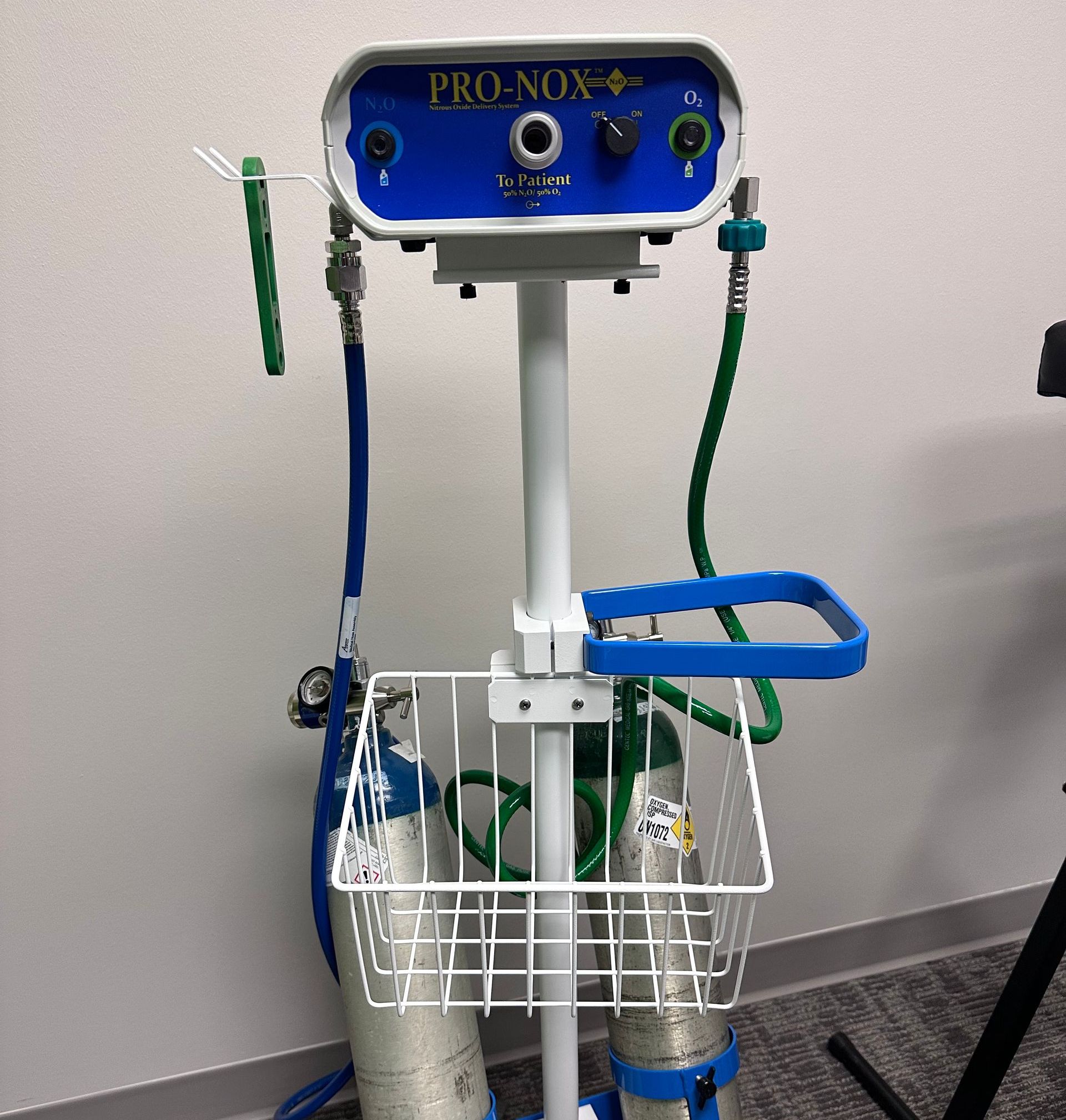 PRO-NOX analgesia system on a stand with tanks and hoses. White, blue, and green color scheme.