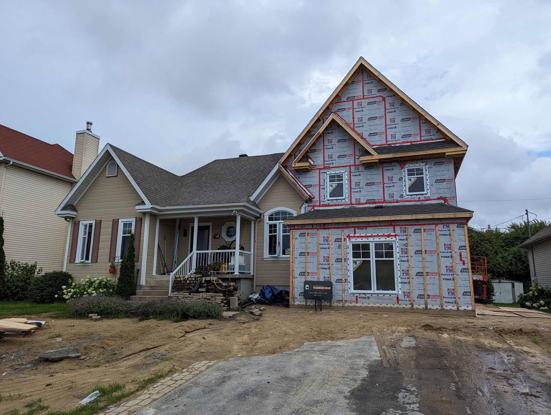 Une maison est en construction au milieu d'un champ de terre.