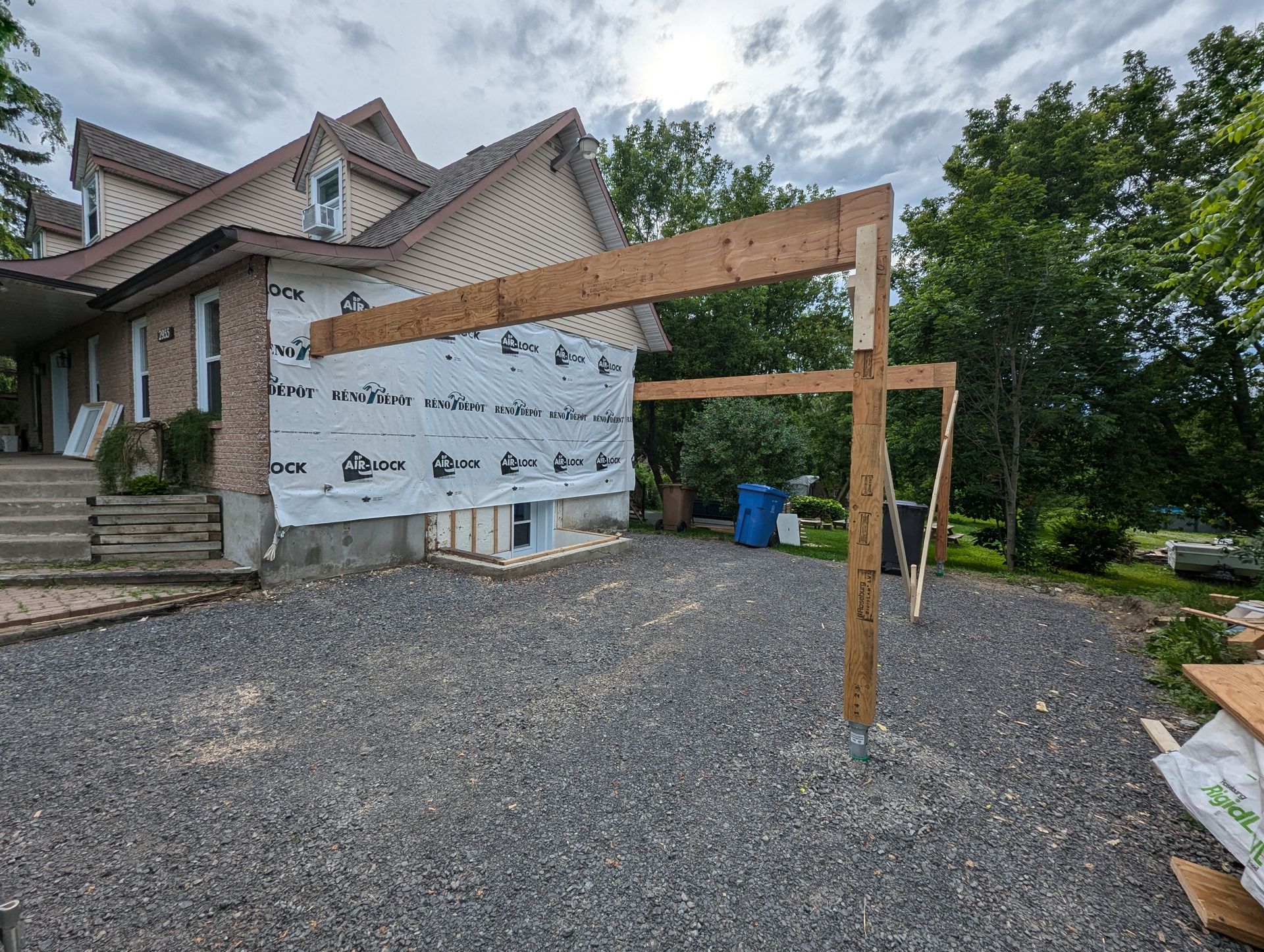 Une structure en bois est en train d'être construite devant une maison.