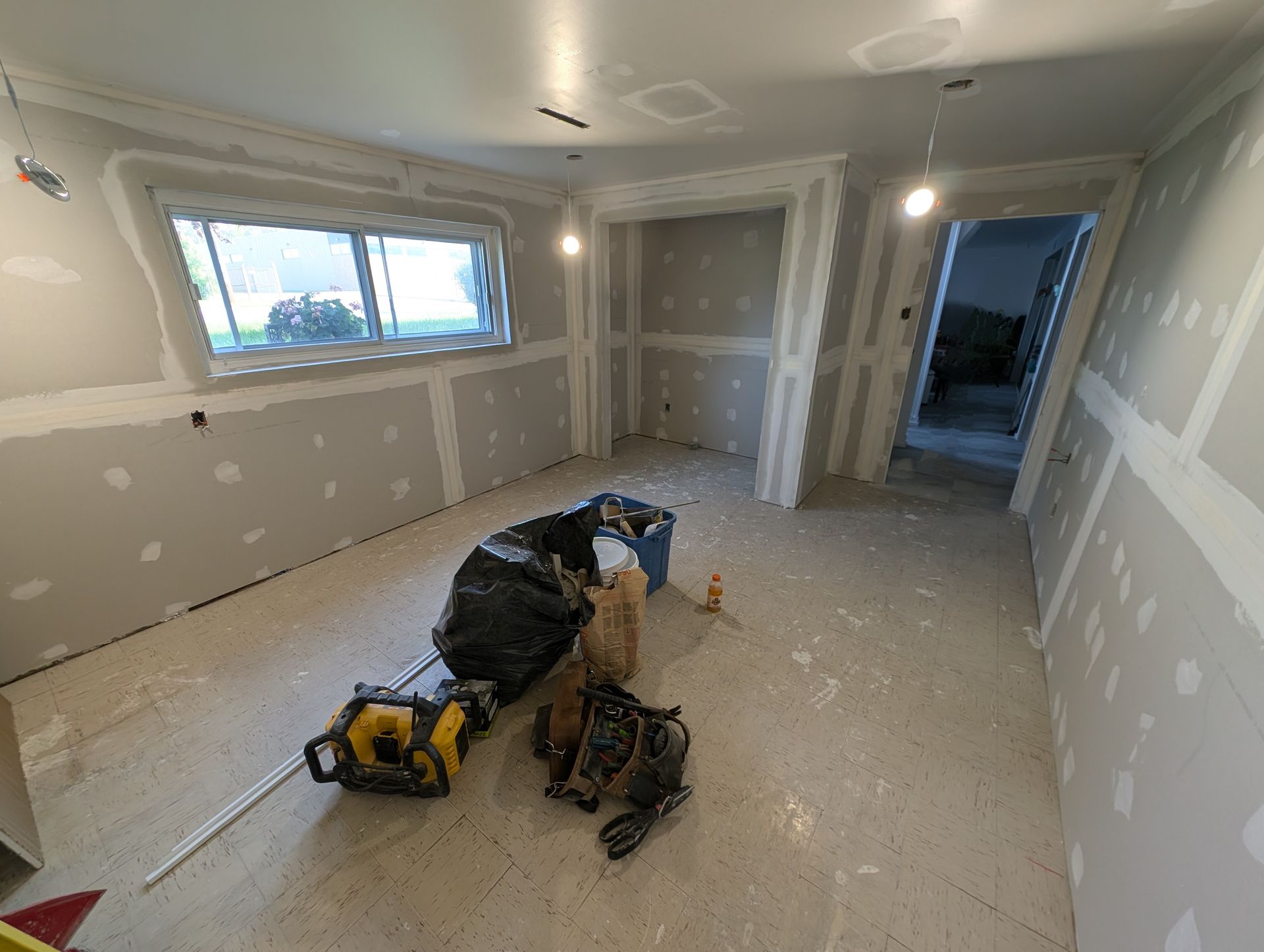 Une pièce en cours de rénovation avec beaucoup d'outils au sol.
